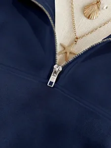 Dettaglio della cerniera argentata su una felpa a maniche lunghe blu navy da donna