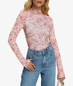 Primer plano de top de malla con flores rosas, cuello alto y estampado delicado