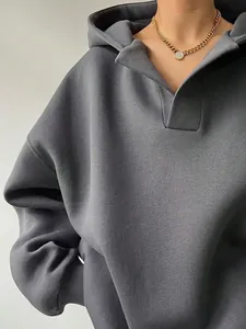 Detaillierte Nahaufnahme des dunkelgrauen Oversized-Kapuzenpullovers mit Stofftextur