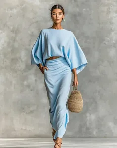 Elegant light blue two-piece set with long sleeve top and high-waisted maxi skirt detail.