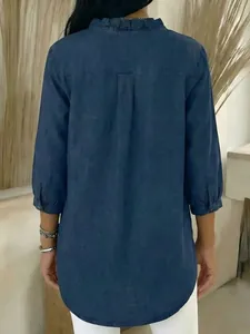 Back view of women's casual dark blue faux denim shirt with ruffled collar detail