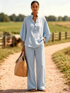 Elegante lichtblauwe linnen set met een blouse met knopen en een wijde lange broek