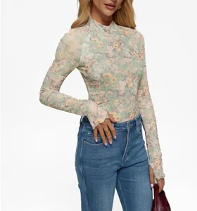Detalle de la camiseta de manga larga de malla floral con agujeros para los pulgares y cuello alto