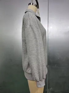 Vista laterale di una felpa grigia con zip e vestibilità ampia per moda donna su manichino.
