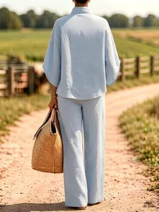 Elegante achterkant van een lichtblauwe linnen set voor dames met shirt en wijde broek