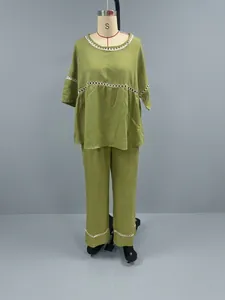 Full view detail of olive green linen-like two-piece set with white eyelet lace trim details.