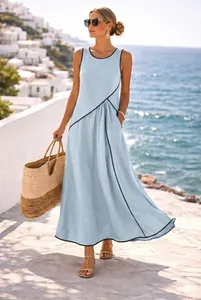 Abito lungo azzurro stile mediterraneo con profili neri in strada costiera soleggiata