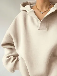 Detailansicht eines cremefarbenen Oversize-Damenkapuzenpullovers mit V-Ausschnitt Kragen.