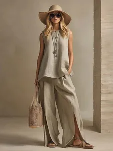 Stylish woman in a beige sleeveless linen top and split-hem wide-leg pants with straw hat