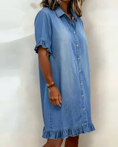 Detail view of denim-look shirt dress featuring delicate ruffle hem and button-down front.