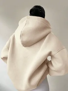 Rückansicht eines übergroßen beige Kapuzenpullovers mit überschnittenen Schultern.