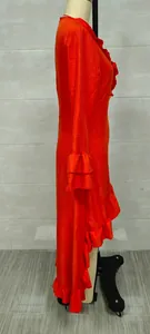 Side view detail of a vibrant orange bohemian ruffle dress shown on a studio mannequin