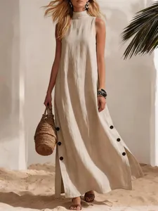 Detailed view of a sleeveless linen maxi dress with side slits and black button accents