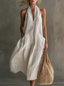 Détail d'une robe licou blanche à col en V avec poches plaquées et texture en lin léger
