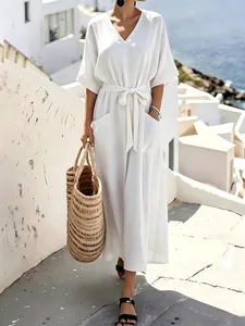 Elegant white short-sleeved maxi dress featuring a tie waist for a relaxed resort look