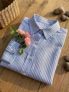 Gedetailleerde weergave van een blauw-wit gestreept katoenen overhemd op houten achtergrond