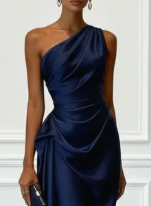 Detailed view of an elegant navy blue one-shoulder satin evening gown with draped pleats
