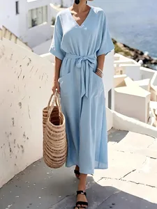 Detail view of a light blue short-sleeved maxi dress with a waist belt and pockets