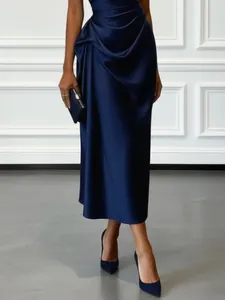 Close-up of elegant navy blue satin evening dress featuring sophisticated pleated draping details