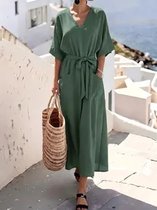 Loose green short-sleeved maxi dress with tie waist belt and pockets for vacation style