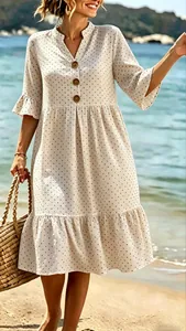 Detail view of a white polka dot V-neck dress with ruffle sleeves and button accents