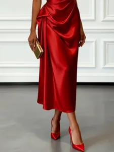 Close-up of elegant red satin pleated sleeveless evening gown with waist draping