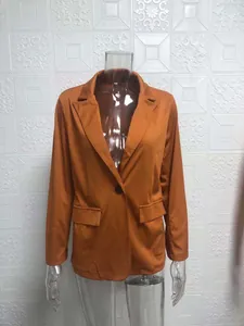 Vista detallada de un blazer naranja ajustado en un maniquí transparente para oficina