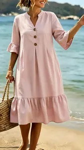 Detailed view of light pink V-neck bohemian vacation dress with ruffled sleeves and buttons