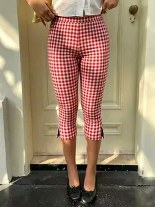 Primer plano de pantalones capri Y2K de cuadros rojos y blancos con abertura lateral.