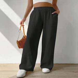 Detail of black loose wide-leg trousers with elastic waistband and side pockets