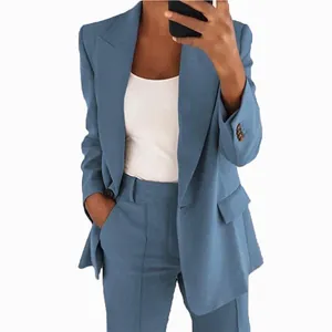 Selfie en el espejo de una mujer con un traje de chaqueta azul entallado de dos piezas