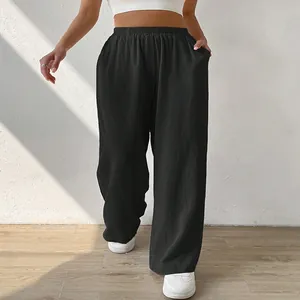 Detail of loose black wide-leg trousers with elastic waist and relaxed fit