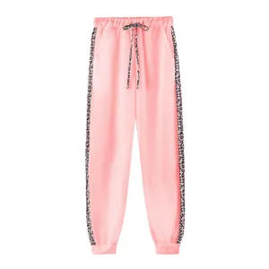 Dettaglio dei pantaloni sportivi rosa con strisce laterali e coulisse leopardate