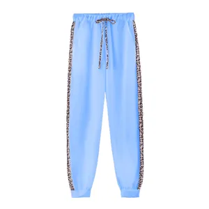 Pantaloni jogger azzurri da donna con strisce laterali e coulisse stampa leopardata.