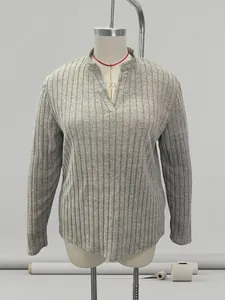 Detail view of a gray ribbed V-neck long-sleeved top on a professional tailor mannequin
