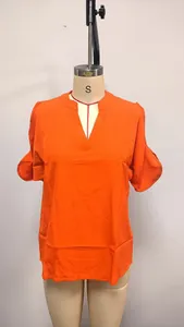 Detailed front view of an orange V-neck blouse with stylish cold shoulder sleeves on mannequin