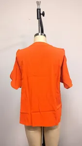 Detailed back view of a vibrant orange cold shoulder fashion top on a mannequin stand