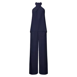 Dettaglio del completo a due pezzi blu navy con scollo all'americana e pantaloni larghi
