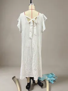 Back view of a white cotton linen summer dress featuring a stylish tie-back bow detail