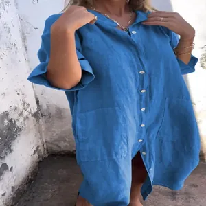 Close-up detail of a loose blue linen cotton shirt dress with functional buttons