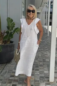 Senior model showcasing a stylish white cotton linen dress with elegant ruffle sleeves