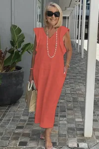 Detail view of a coral cotton linen maxi dress with ruffle sleeves and V-neck on a model