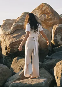 Detailed back view of high-waisted irregular yoga pants in a natural rocky setting