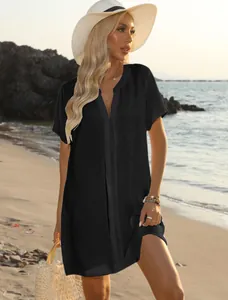 Full-length view of a woman wearing a casual black V-neck beach dress at the seaside.
