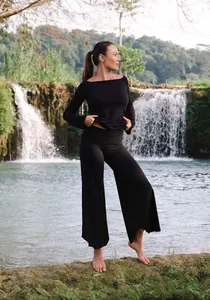 High-waisted black yoga pants with irregular hems in a natural waterfall setting.