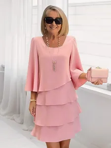 Elegant mature woman wearing a light pink tiered cake dress with stylish three-quarter sleeves
