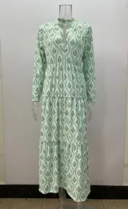 Vestido largo verde menta con estampado de hojas y falda de volantes en maniquí.