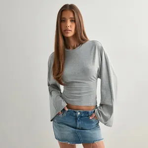 Detailed view of a grey long-sleeve top featuring wide flared sleeves and a cinched waist