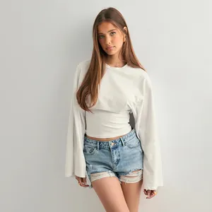 Detail view of a white slim-fit top with unique wide flared sleeves on a model