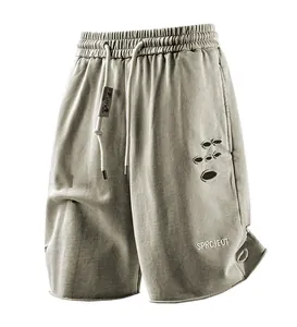 Detail shot of men's distressed cargo shorts with SPRCJEOT embroidery and ripped design.